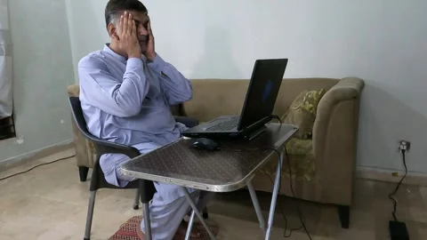 Asian man grabs head in frustration after laptop error Stock Footage 313741133