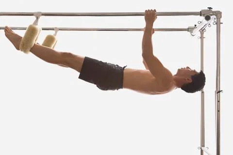 Asian man hanging on exercise equipment Stock Photos