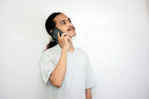 Asian man with a happy expression while receiving an incoming call Stock Photos
