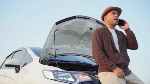 Asian man has  broken down car on the road he talking on phone to call someone t Video stock 149805197