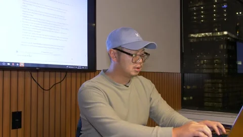 Asian man in hat working on chatgpt AI on computer Stock Footage 232566352