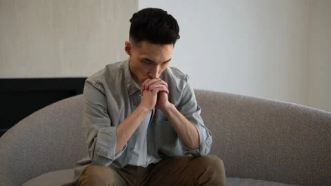 Asian man with headache thinks about solving problem Stock Footage 182395881