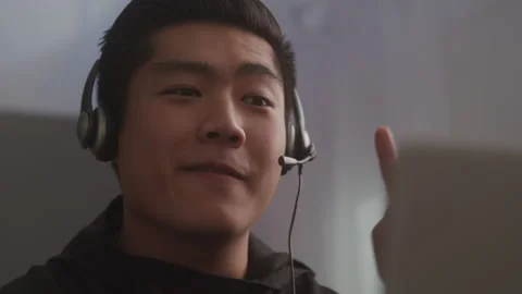 Asian Man with a Headset Working Tech Support Stock Footage 208787771