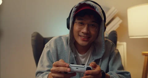 Asian man hold joystick controller excitement and focus playing video games. Stock Footage 229560948