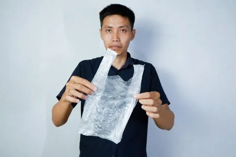 Asian man holding empty plastic bag Stock-Fotos