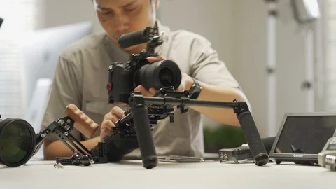 An Asian man is installing a camera rig and fastening it Video stock 128407025