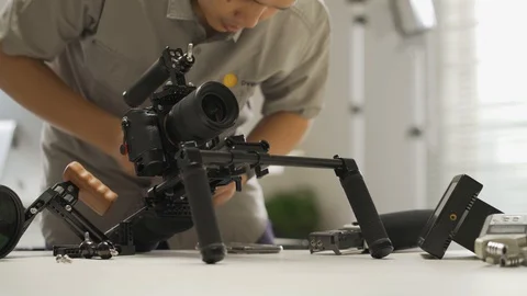 An Asian man is installing a camera rig and fastening it Stock Footage 128407091