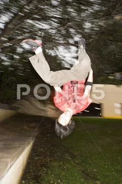 Asian Man Jumping Upside-Down In Park