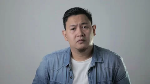 Asian man looking at camera sad and regret expression, disappointed upset Video stock 143517486