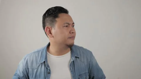 Asian man looking at camera with sad and regret expression, disappointed  Stock Footage 143772316