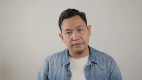 Asian man looking at camera with sad and regret expression, disappointed  Stock Footage 143772862