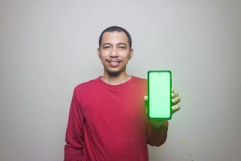 Asian man looking to camera, smiling and showing empty blank white copy spa.. Stock Photos