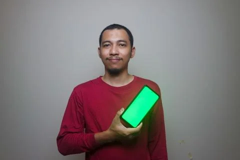 Asian man looking to camera, smiling and showing empty blank white copy spa.. Stock Photos