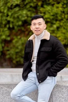 Asian man looking at the camera while posing outdoors in a park. Foto stock