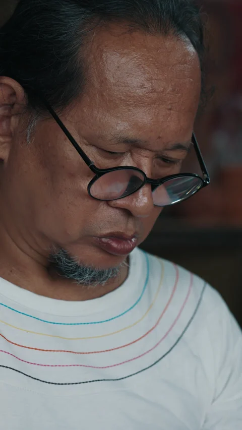 Asian man looking down while working on details of handmade Stock Footage 315662007