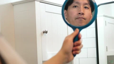 Asian man looking at a mirror Video stock 331957998