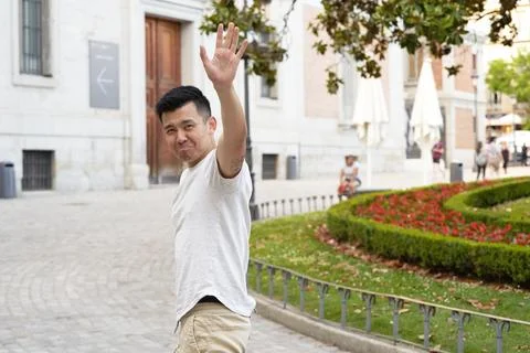 Asian man looking sad while waving hand to say goodbye to someone. Fotos Stock