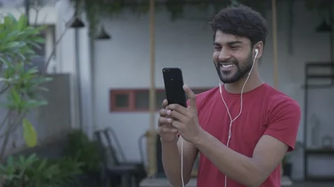Asian man making face to face video call his smart phone at home outdoor. Видео 154036828