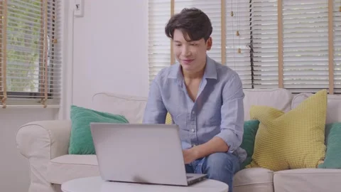 Asian man making facetime video calling with smartphone at home. He's waving  Stock Footage 167721204