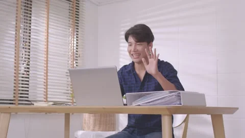 Asian man making facetime video calling with laptob at home.Using conferencin Stock Footage 167722909