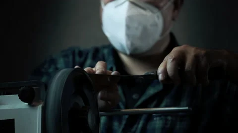 Asian man with mask sharpens knives on a grinder. Close up hand Stock-Footage 142157345