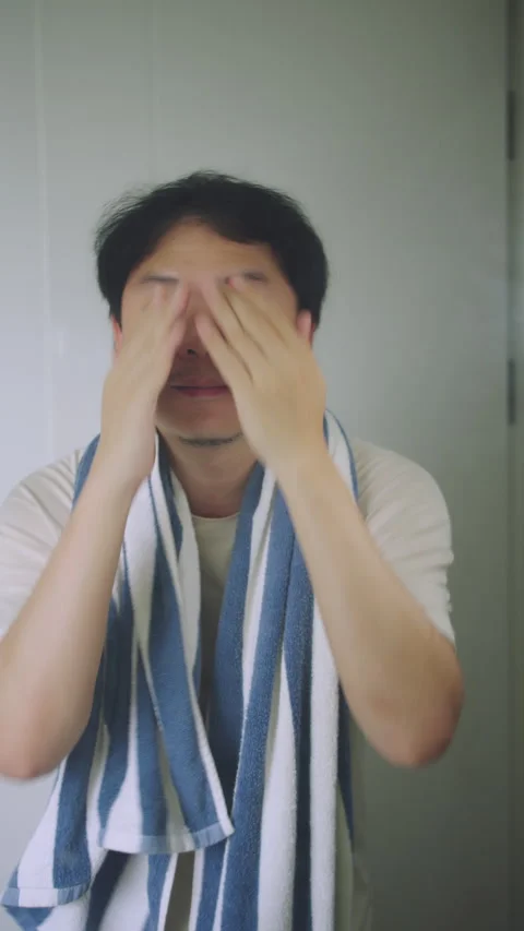 Asian Man Massaging His Face and Checking Skin in Bathroom Mirror, Men Skincare  Stock Footage 337769324