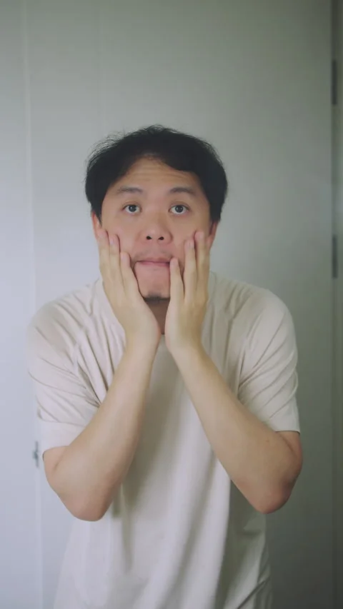 Asian Man Massaging His Face and Checking Skin in Bathroom Mirror, Men Skincare  Stock Footage 337769389
