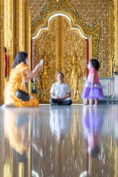Asian Man meditates on the ground with reflection in the sunlight pouring i.. Stock Photos
