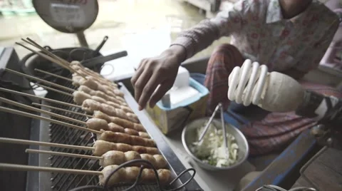 Asian man picking up a meat ball kebab stick ready for grill cooking Stock Footage