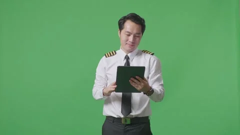 Asian Man Pilot Using A Tablet While Standing In The Green Screen Background Stock Footage 244394910