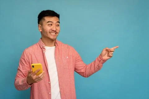 Asian man pointing to the side in studio. Foto stock