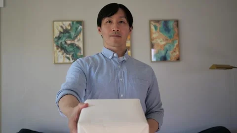 Asian man presenting a box wrapped gift Stock-Footage 295315486
