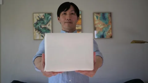 Asian man presenting a box wrapped gift Vidéo 295315504
