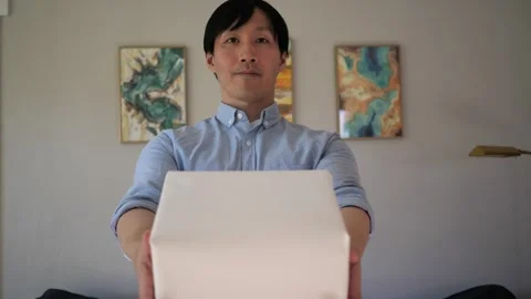 Asian man presenting a box wrapped gift Vidéo 295315506