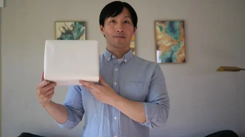 Asian man presenting a box wrapped gift Vidéo 295315509