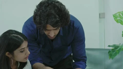 Asian man project coordinator engaged in paperwork with woman staff member. Stock-Footage 168348606