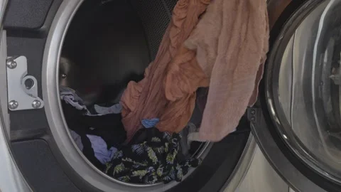 Asian Man pulling clothes inside the washing machine Stock Footage 310280557
