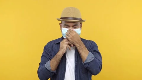 Asian Man put on hat is wearing face mask in studio. Protect himself from virus  Stock Footage 144661689