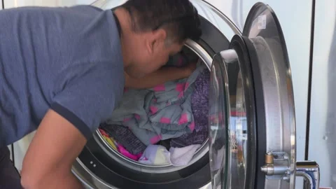 Asian Man putting clothes inside the washing machine Video stock 310228644