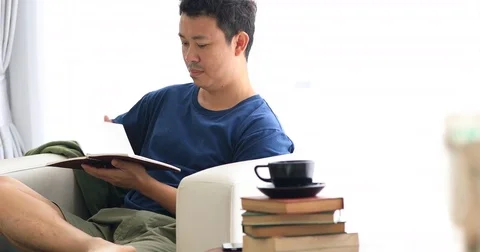 Asian man reading a book with smile face at home. Video stock 80217528