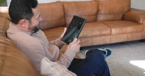 Asian man reading Chat AI business proposal on tablet, scrolling, smiling, Stock Footage 314028177