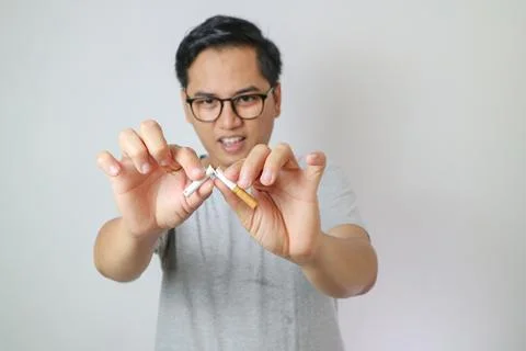 Asian man refusing cigarette concept for quitting smoking. Point to the cig.. Stock Photos