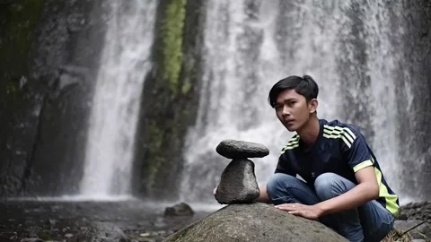 An asian man is relaxing his mind by stacking and balancing stones Stock-Footage 171196495