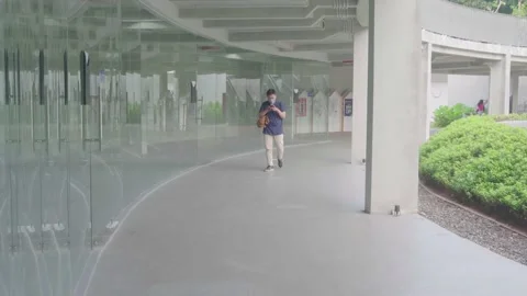 An asian man is replying to messages on his cellphone while walking Stock Footage 221872984