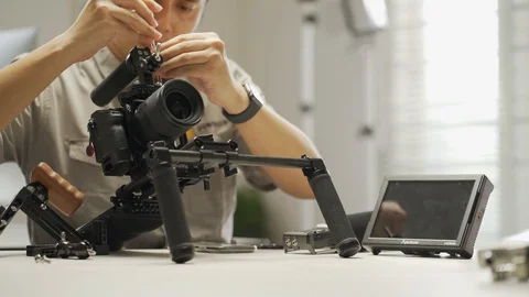 An Asian man is setting a camera rig Video stock 128406958