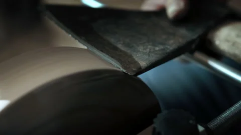 Asian man sharpening axe on a grinder. Macro Stock Footage 143673246