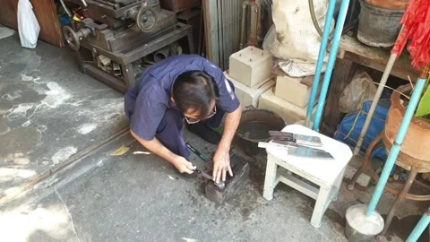 Asian man is sharpening knives using knife sharpening stone in workshop Stock Footage 144519690