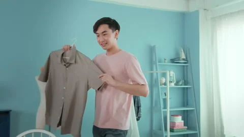 An Asian man is showing clothes in front of smartphone  live streaming at his Stock-Footage 172008017