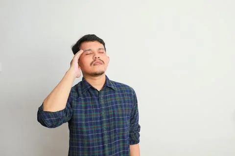 An asian man shows a dizzy expression and holds his head Stock Photos