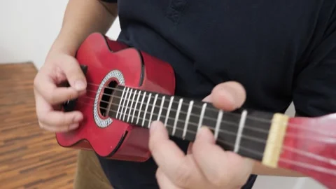 Asian man singing while playing ukulele Stock Footage 293533338